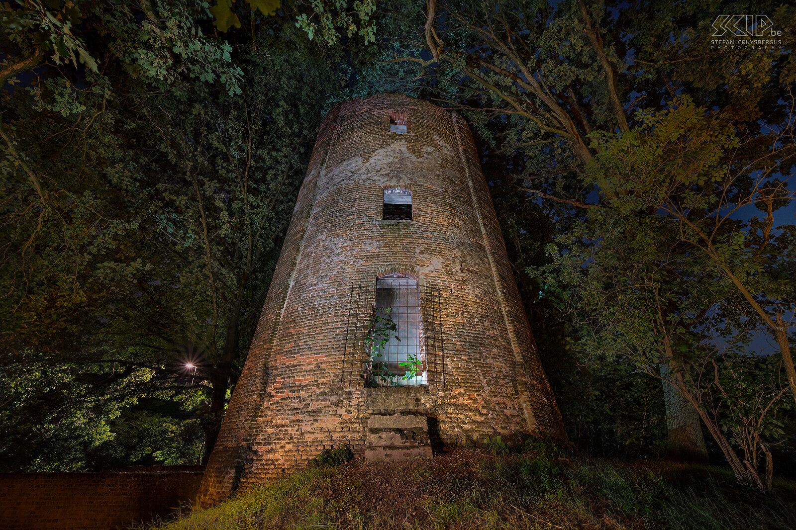 Hageland by night - Mill in Engsbergsen in Tessenderlo The mill in Engsbergsen in Tessenderlo was a grain mill that was built in 1826. The mill has not been in use since 1934 and is now a ruin that stands among the trees in a residential area. The windmill is no longer photogenic at all and yet I tried to make a few atmospheric images of it in the evening with a few flashes and LED lamps. Stefan Cruysberghs